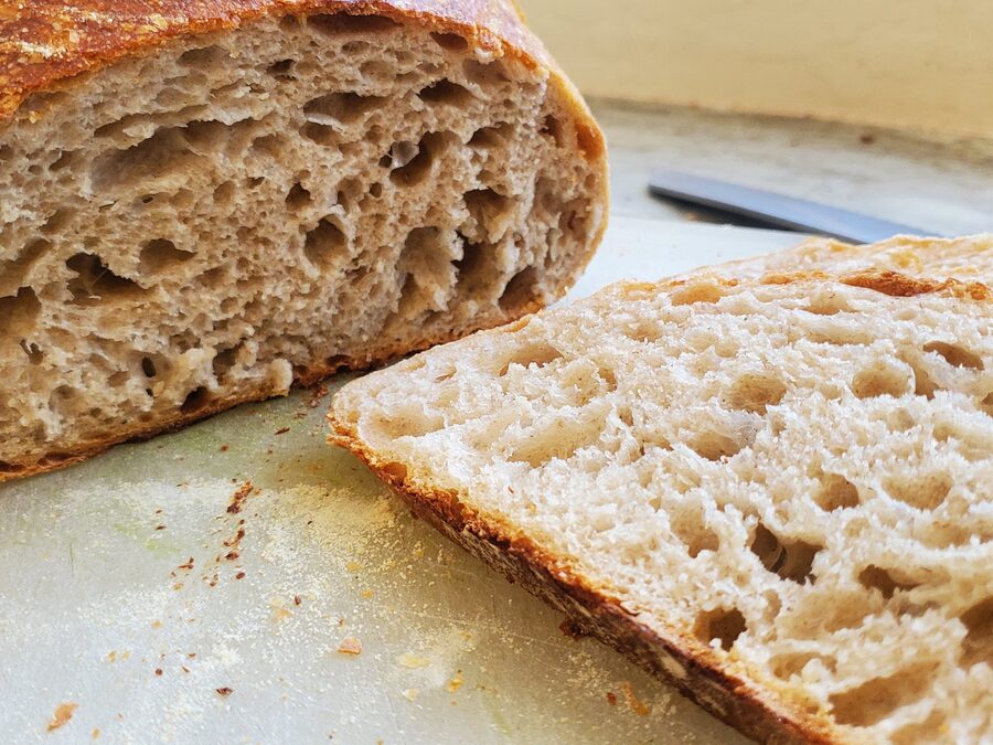 A loaf cut open, showing an open and irregular crumb