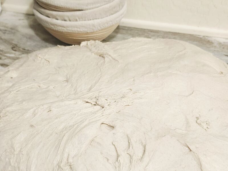 Bulk dough spread across a marble counter